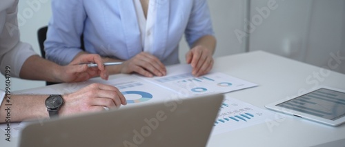 Business colleagues reviewing financial charts and marketing data during an important strategy meeting, analyzing sales reports and performance analytics for growth