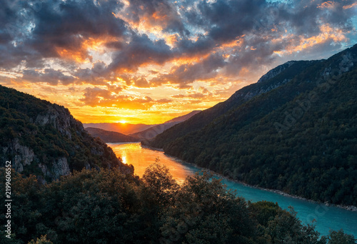Vibrant Sunset Glow Over a Winding River Between Steep Hills