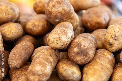 Fotografía Multiple white, medium-sized tuber potatoes in a grocery bin for sale