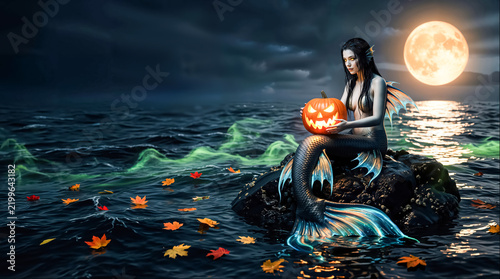 Mystical Mermaid Holding Jack-o'-Lantern on Rock in Sea at Night