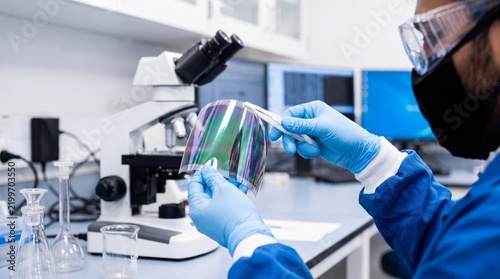 Obraz na plátně Scientist examining flexible thin film semiconductor material with tweezers next