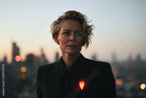 Location pin symbol on businesswoman's suit with city backdrop