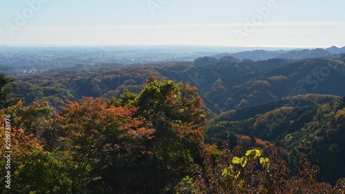 The camera pans across autumn hills overlooking a distant city.