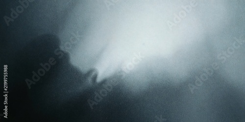 Abstract dark blue background with soft glowing light and grainy texture