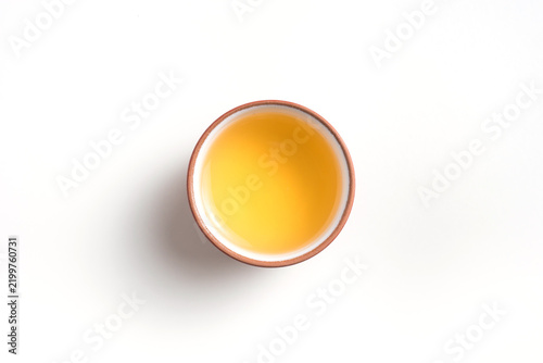 Top view of traditional teacups full of golden oolong tea on white background with copy space