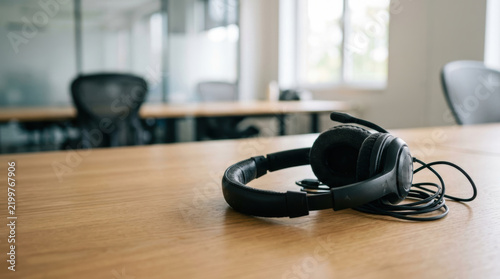 Staffing shortages challenge remote work as headset rests on wooden office desk in quiet workspace