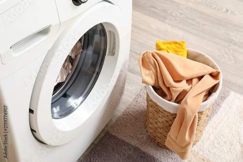 Картината върху платно Household chores and laundry day, modern washing machine with a wicker basket fu