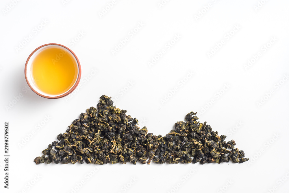 Obraz premium Top view creative flat lay of oolong tea leaves arranged in mountain shape with teacup as sun on white background with copy space