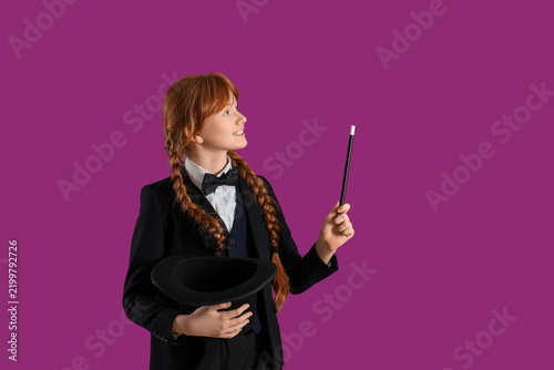Photography Young magician showing magic trick on purple background