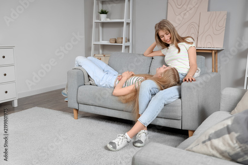 Beautiful young happy sisters sitting at home