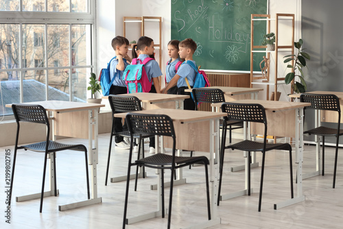 Cute little pupils in classroom. School holidays concept
