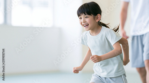 Obraz na płótnie キッズスクールで楽しそうに運動する女の子