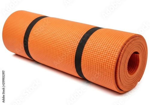 Rolled orange fitness yoga mat with black straps on white background.