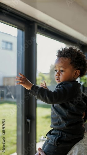 little boy looking out window in the window