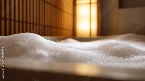 Luxury wellness interior in close up, a deep stone soaking tub filled almost completely with abundant thick white foam, a few subtle bubbles rising