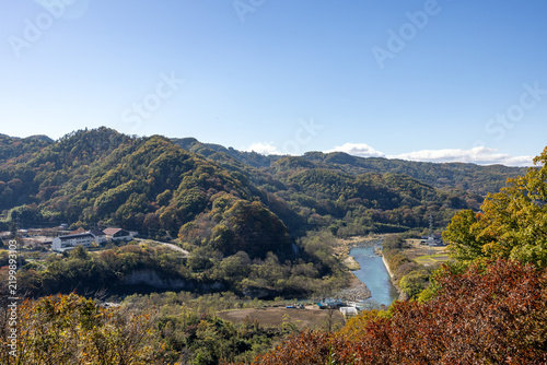 Fototapeta 秋の澄んだ空と色づく山間にゆったりと流れる川と静かな集落の秋風景