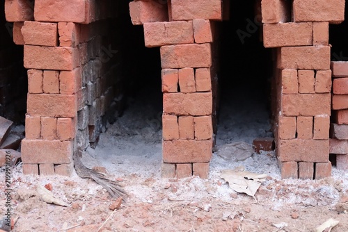 Traditional Red Clay Brick Kiln with Stacked Unfired Bricks in a Rural Indian Village.