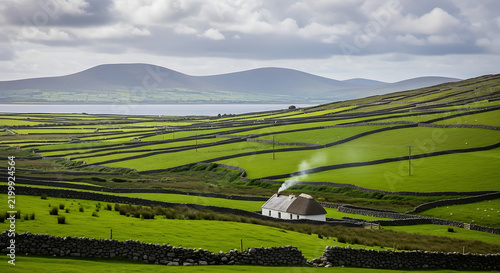 rolling green hills of ireland with stone walls and a lonely cottage
