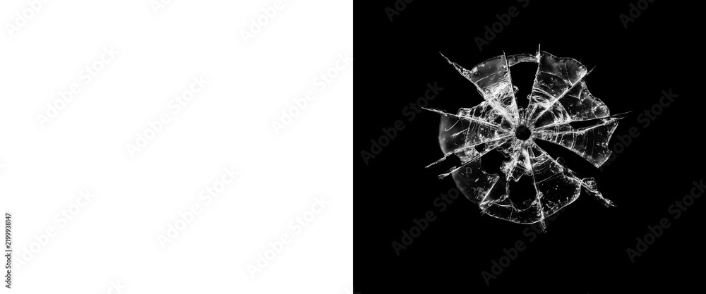 Obraz premium Shattered glass bullet hole on black background, broken window glass texture with radial cracks, realistic bullet impact damage effect