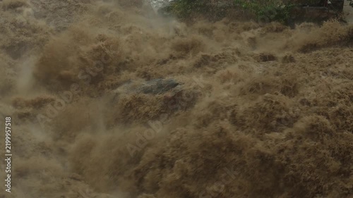 Close up of powerful and muddy floodwaters raging