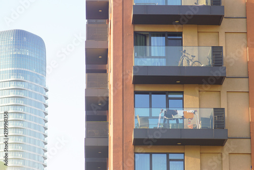 Konstfotografi Lived-in apartment balconies with bicycle and laundry drying rack against glazed tower