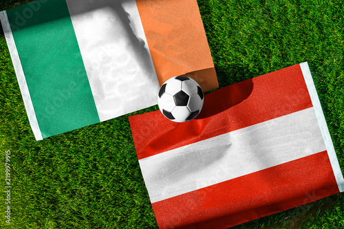 Republic of Ireland vs. Austria football match. National flags on green grass with soccer ball in the middle. Football background for international match.