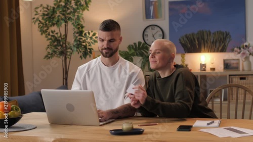 Happy couple shopping online using laptop and credit card