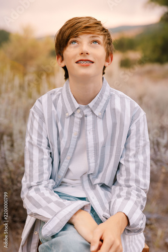 Teenage boy with braces looking up hopefully outdoors