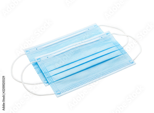 Two blue disposable surgical face masks with white elastic ear loops, stacked on of each other, isolated on a black background isolated on a transparent background