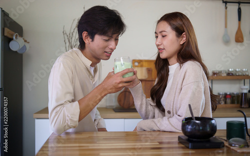 Картината върху платно Young Asian couple enjoying a fresh homemade matcha latte together