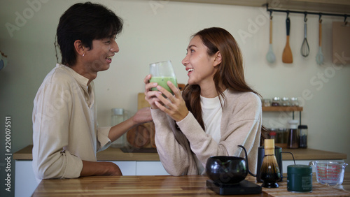 Fotografie Young Asian couple relaxing together with fresh matcha latte at home