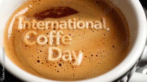 Freshly poured espresso cup with artistic foam crema spelling International Coffee Day message for morning celebration