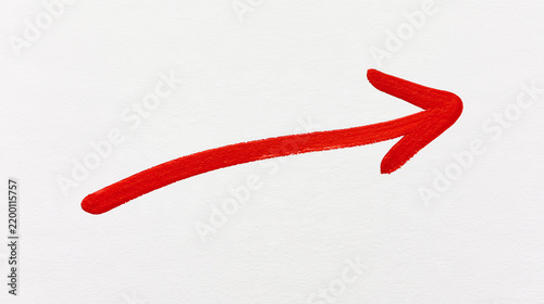 Red marker arrow pointing right hand side drawn on white paper texture