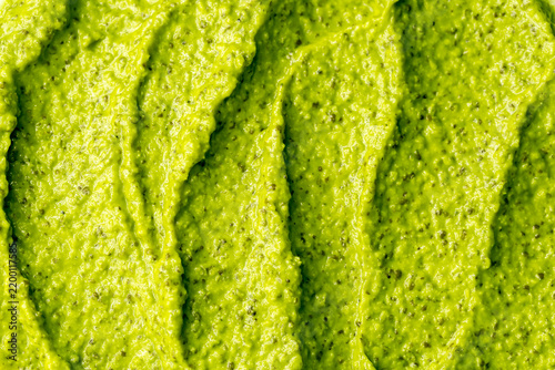 Green yogurt ice cream with pistachios, kiwi and avocado. Fresh fruit smoothie. Ice cream texture. Delicious sweet dessert close-up as background.