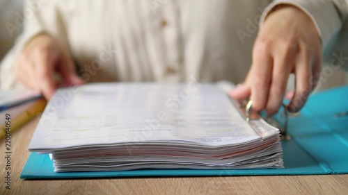 Close Up of Hands Holding Thick Blue Ring Binder with Documents, Office Paperwork and Archiving Concept