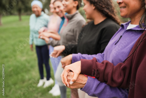 Women's circle during a group yoga class with people of different age and body types - Healthy lifestyle, female connection and meditation concept - Main focus on close up hand