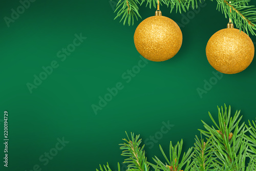 Christmas decorations and spruce branches on a green background. Copy space.