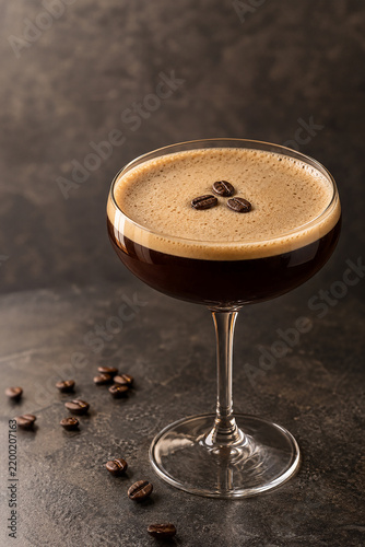 Espresso martini cocktail with coffee beans in a coupe glass on a dark background