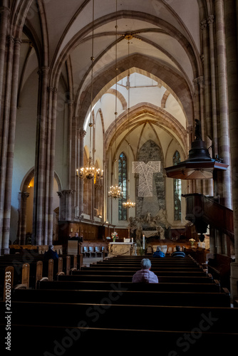 Intérieur d'une église gothique avec voûtes, colonnes, autel, chandeliers et crucifix monumental (église Saint-Thomas, Strasbourg, France)