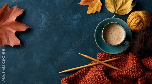 Cozy fall background with knitting supplies and cup of coffee