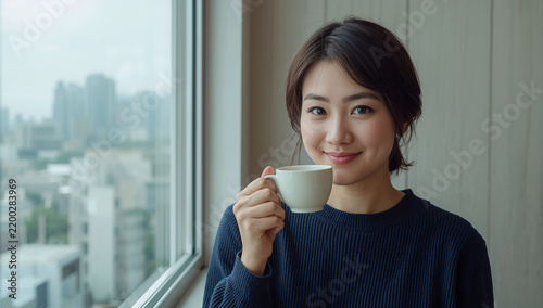 Tapety artystyczne 窓際でコーヒーカップを持って微笑む日本人女性