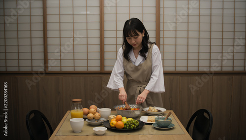 Obraz na płótnie 和風の食卓で料理を混ぜる日本人女性