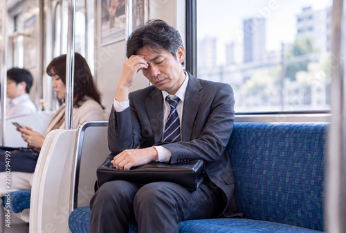 Tapety artystyczne 電車の座席で疲れて頭を抱える中年会社員