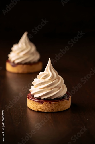 Dessert With Whipped Cream on Top and Fruit Sauce on a Cookie Base