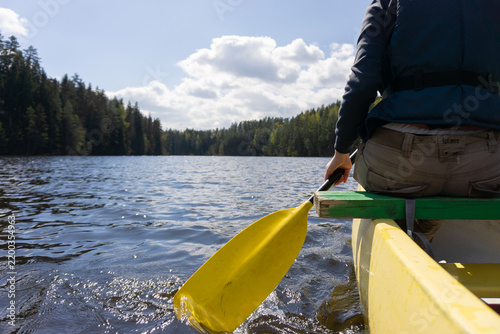 Canoeing adventure on a calm forest lake in Estonia with sunlight and scenic nature