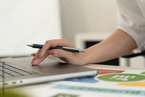 A diverse business team analyzing environmental charts and graphs in a collaborative meeting to create sustainable strategies in a modern office.