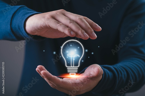 Canvas Print Innovation concept, a professional holding a glowing light bulb between hands, representing creativity, ideas, inspiration, problem solving, technology, business development, future opportunities