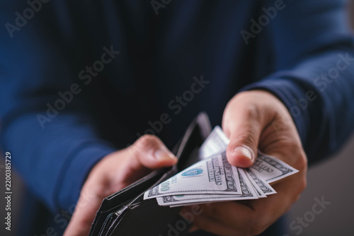 Canvastavla Close-up of a person holding US dollar bills from a wallet, representing cash, money, personal finance, income, spending, savings, budgeting, payment, wealth, and everyday financial management
