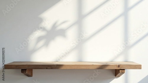Rustic wooden shelf against a white wall with sunlit shadows creating a minimalist, serene display space