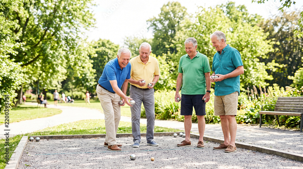 Fototapeta premium Group of senior friends playing petanque together in park